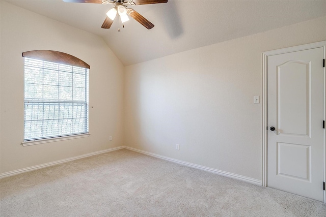 empty room with vaulted ceiling, ceiling fan, and light carpet