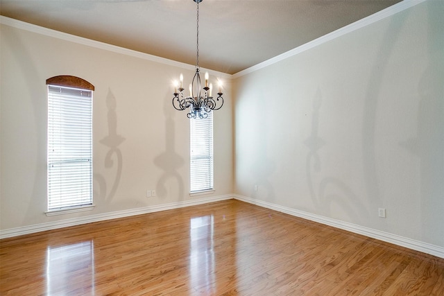 unfurnished room featuring hardwood / wood-style flooring, a wealth of natural light, crown molding, and a chandelier