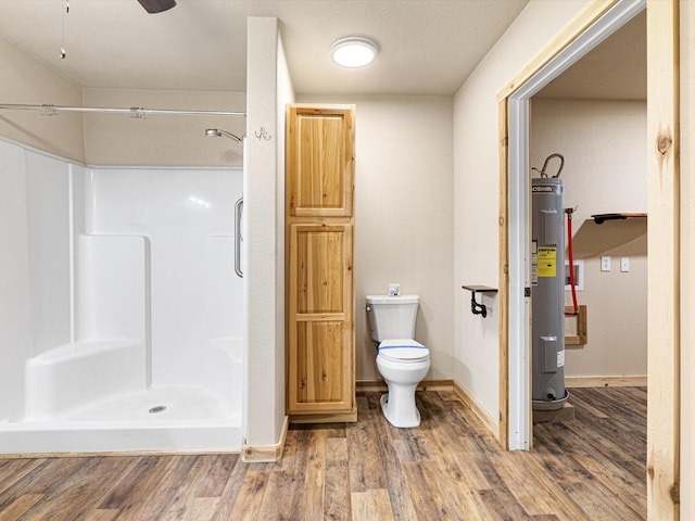 bathroom with ceiling fan, toilet, wood-type flooring, water heater, and a shower