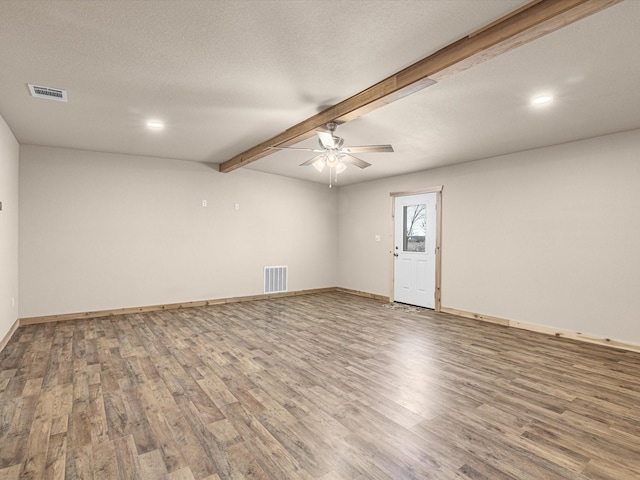 spare room with beam ceiling, ceiling fan, a textured ceiling, and hardwood / wood-style floors