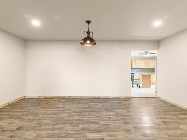 spare room with recessed lighting, a ceiling fan, baseboards, and wood finished floors