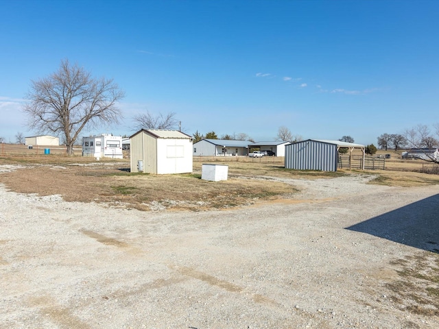 view of yard featuring a storage shed, fence, and an outdoor structure
