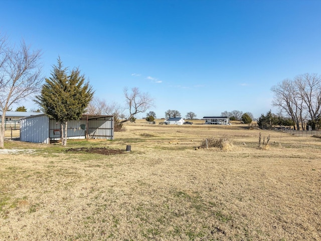 view of yard with an outbuilding and a rural view