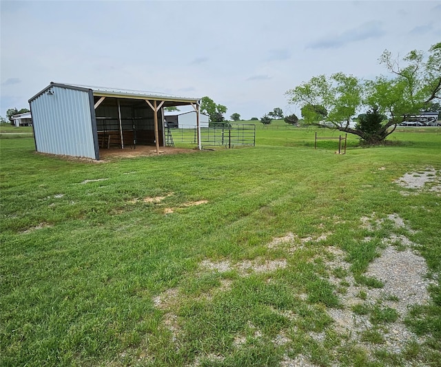 view of yard with fence, a pole building, and an outbuilding