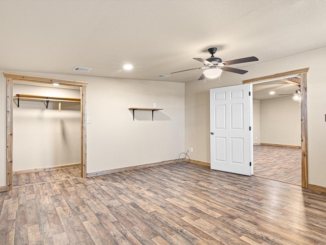 unfurnished bedroom featuring ceiling fan, a closet, and hardwood / wood-style flooring