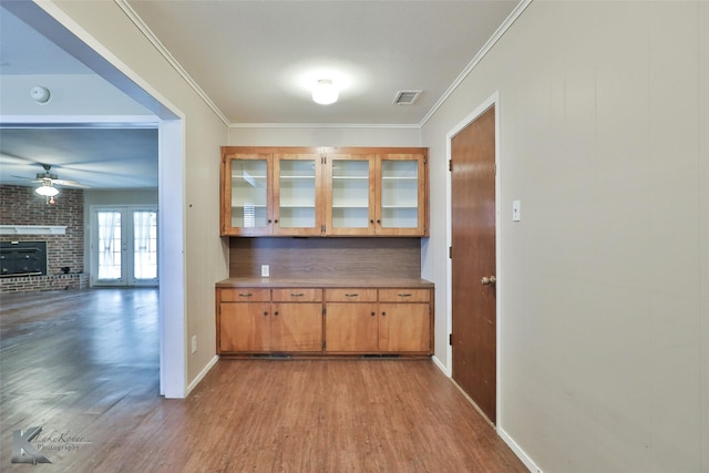 bar with ceiling fan, crown molding, light hardwood / wood-style flooring, and french doors