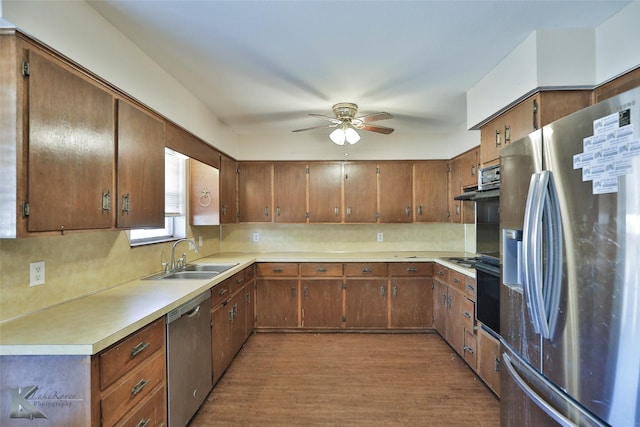 kitchen with ceiling fan, backsplash, hardwood / wood-style floors, sink, and stainless steel appliances