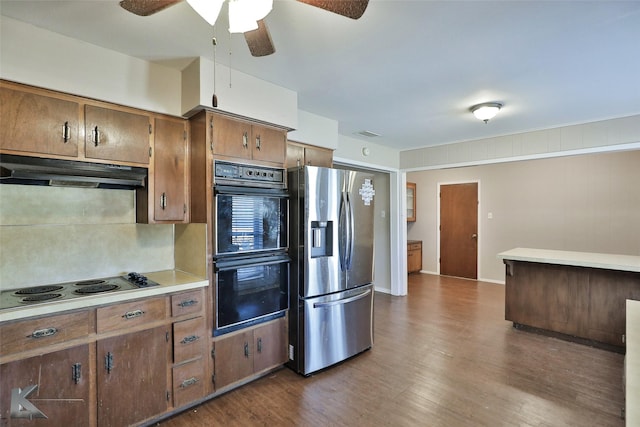 kitchen with dark hardwood / wood-style floors, cooktop, stainless steel fridge, and double oven