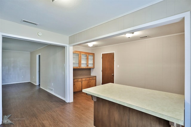 kitchen featuring dark hardwood / wood-style flooring and crown molding