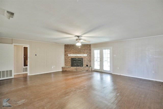 unfurnished living room with ceiling fan, a brick fireplace, dark hardwood / wood-style flooring, french doors, and crown molding