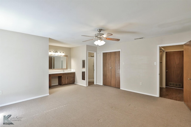 interior space with ceiling fan and light colored carpet