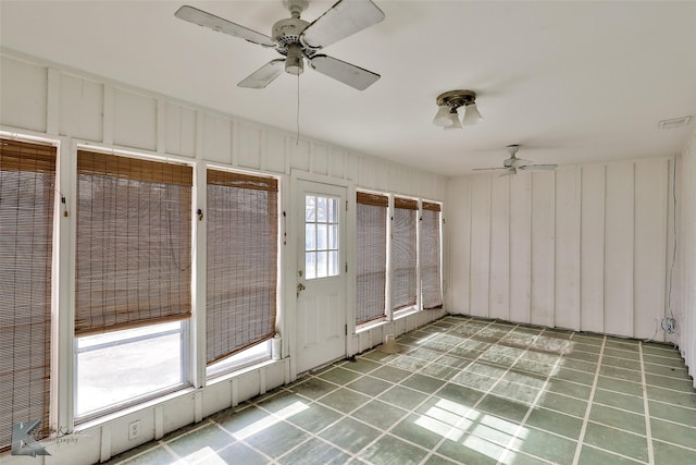 unfurnished sunroom featuring ceiling fan