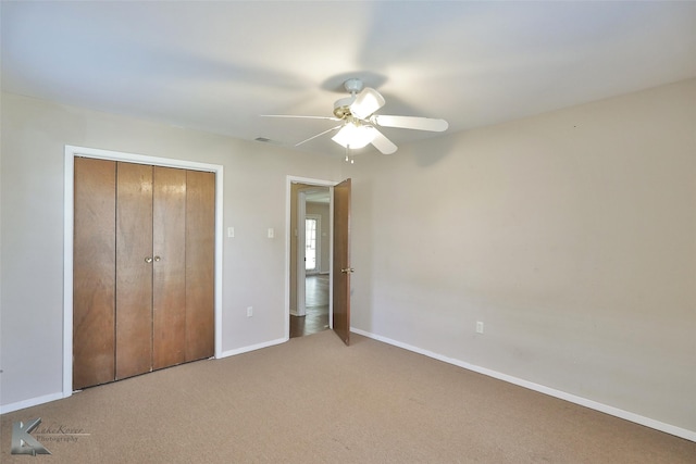 unfurnished bedroom with ceiling fan, a closet, and carpet flooring