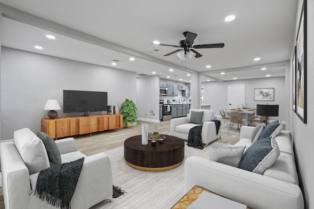 living room with sink, ceiling fan, and light wood-type flooring