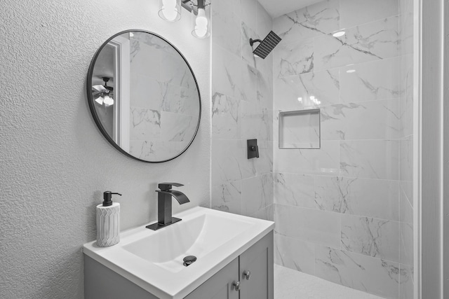 3832 Stateoak Dr, Dallas, TX 75241 - bathroom featuring a tile shower, vanity, and a textured wall
