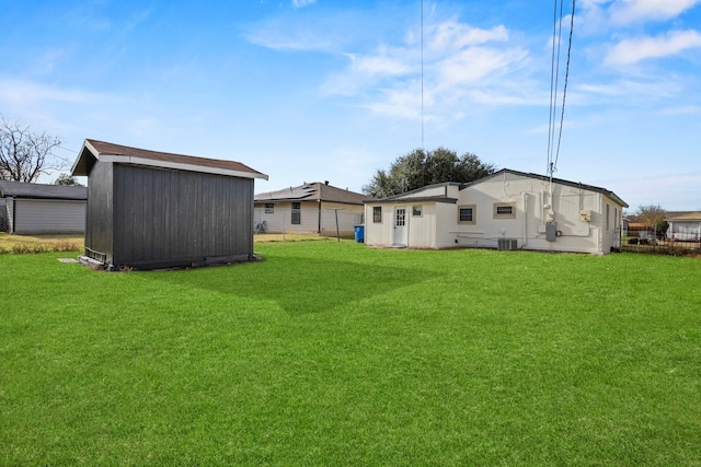 view of yard with central AC and a storage unit