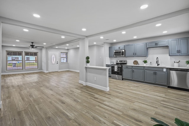 kitchen featuring sink, gray cabinets, stainless steel appliances, and light wood-type flooring