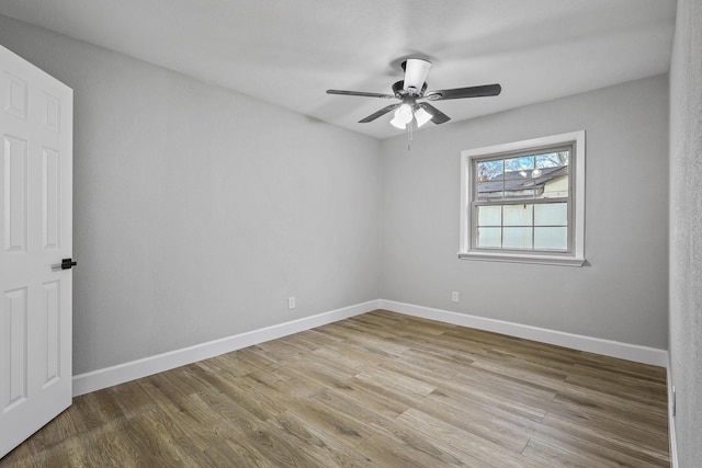 empty room with ceiling fan and light hardwood / wood-style flooring