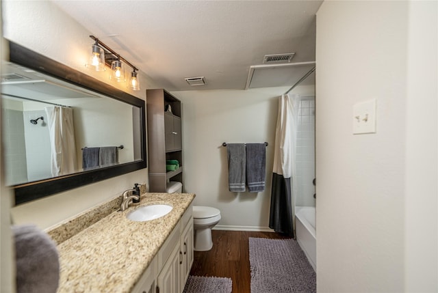 full bathroom with toilet, hardwood / wood-style flooring, shower / bath combo with shower curtain, a textured ceiling, and vanity