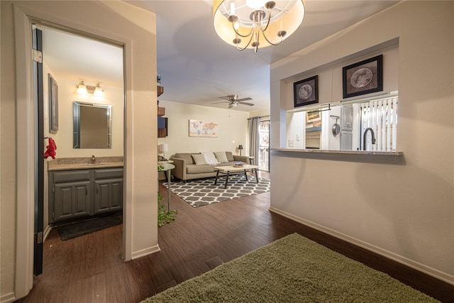 hall featuring dark hardwood / wood-style flooring, sink, and a chandelier