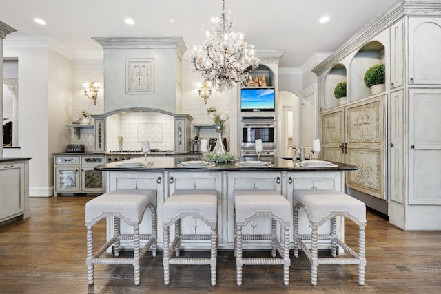 kitchen with tasteful backsplash, dark wood-type flooring, a kitchen breakfast bar, and pendant lighting