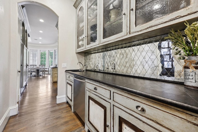 kitchen with dishwasher, dark hardwood / wood-style flooring, sink, backsplash, and ornamental molding