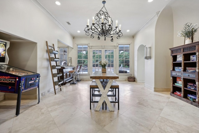 dining room with ornamental molding and a notable chandelier