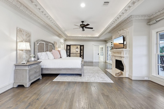 bedroom with ceiling fan, dark hardwood / wood-style floors, a raised ceiling, and crown molding