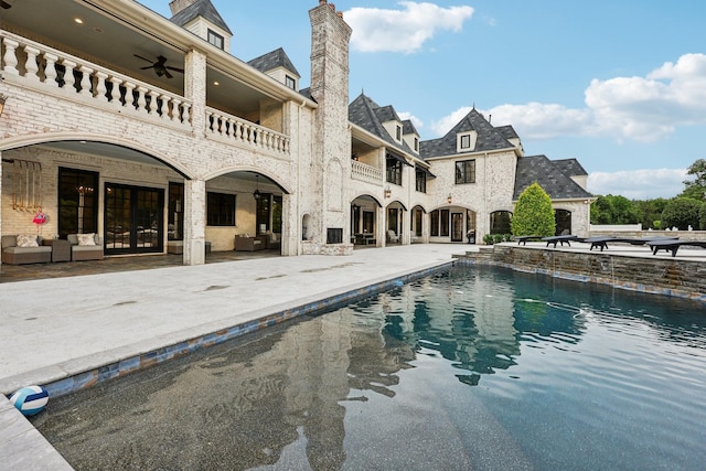 view of swimming pool featuring ceiling fan and a patio