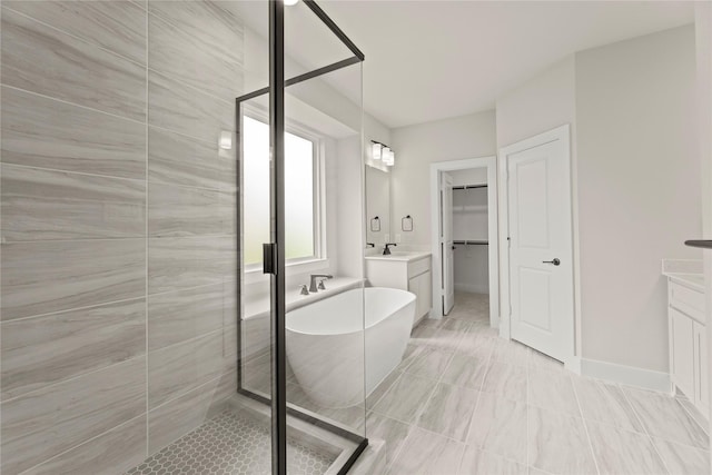 13728 Riola Dr, Little Elm, TX 75068 - bathroom featuring a stall shower, a soaking tub, vanity, and a walk in closet