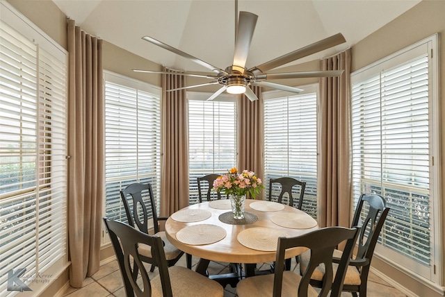 tiled dining room with ceiling fan and lofted ceiling