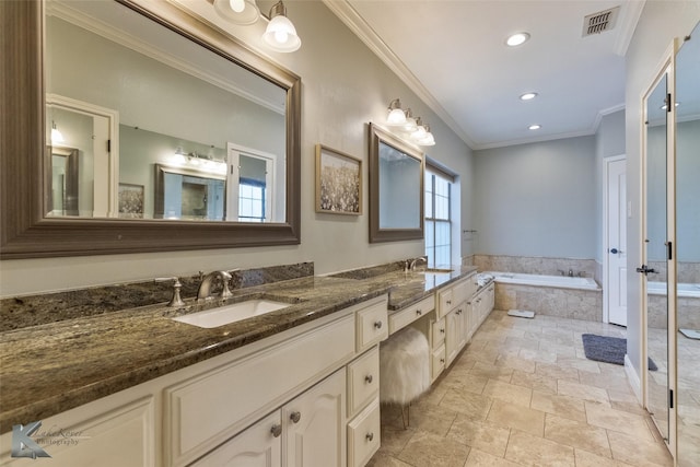 bathroom featuring vanity, crown molding, and tiled tub