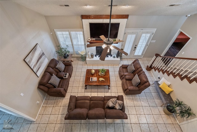 tiled living room featuring ceiling fan and a textured ceiling