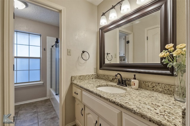 bathroom featuring tile patterned floors, enclosed tub / shower combo, and vanity