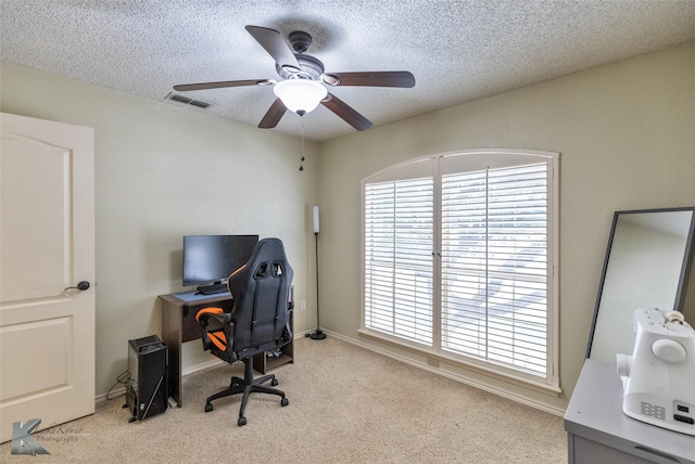 home office featuring ceiling fan, light colored carpet, and a textured ceiling