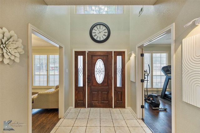 entryway featuring light tile patterned floors and ornamental molding