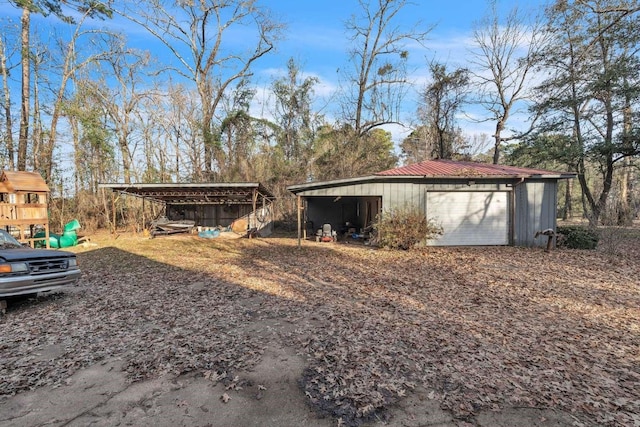 view of outdoor structure featuring a garage, a playground, and a carport