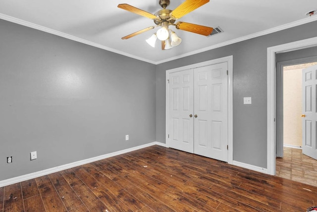 unfurnished bedroom with ceiling fan, dark hardwood / wood-style flooring, a closet, and ornamental molding