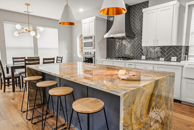 kitchen featuring light stone countertops, hanging light fixtures, tasteful backsplash, and a kitchen island