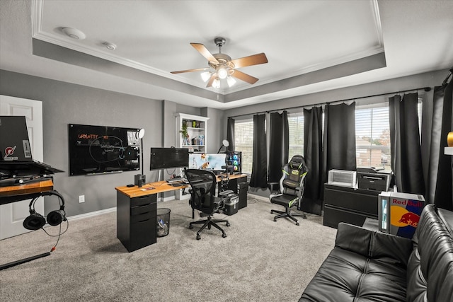 carpeted office featuring ceiling fan, crown molding, and a raised ceiling