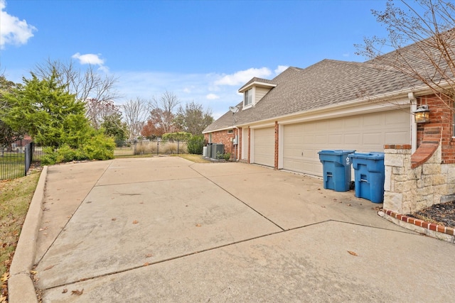 view of side of home with a garage and central AC