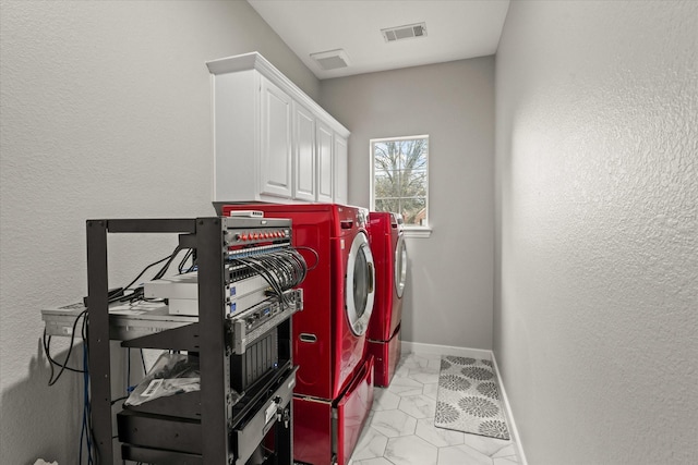 laundry area featuring washing machine and dryer and cabinets