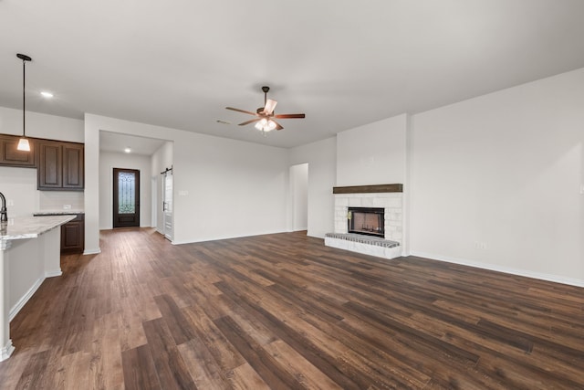 120 Roosevelt Ln, Valley View, TX 76272 - unfurnished living room with dark wood-style flooring, baseboards, recessed lighting, a fireplace with raised hearth, and a ceiling fan