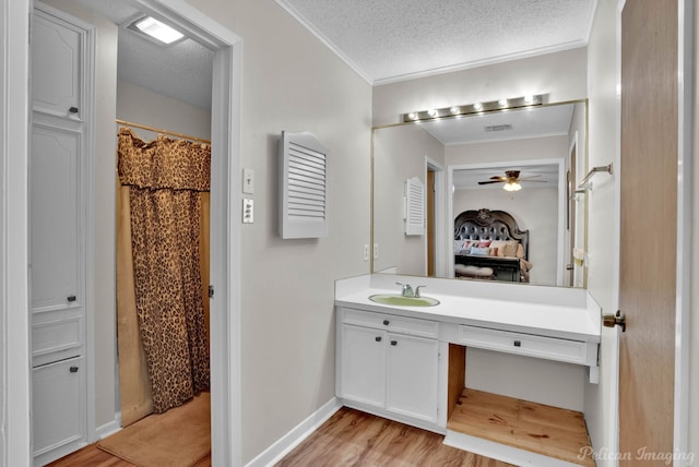 bathroom featuring wood-type flooring, a textured ceiling, walk in shower, and vanity