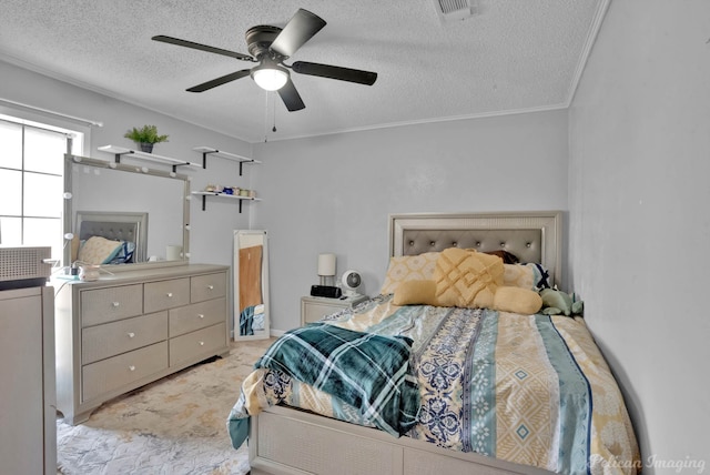 bedroom with ceiling fan, a textured ceiling, and ornamental molding