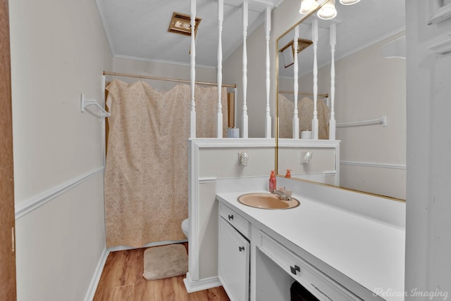 bathroom with toilet, ornamental molding, hardwood / wood-style flooring, and vanity