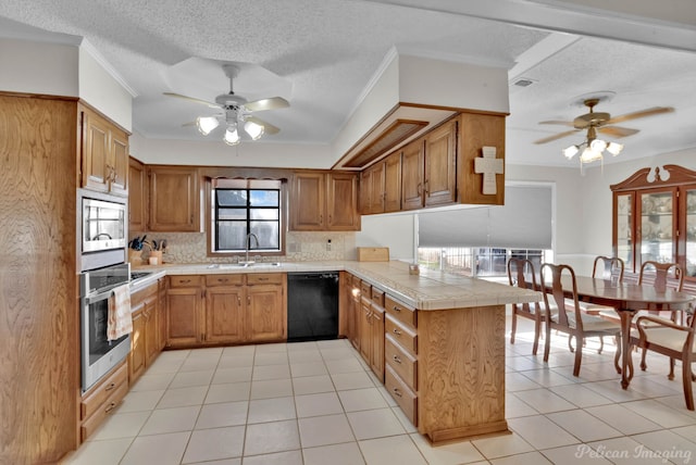 kitchen with a textured ceiling, appliances with stainless steel finishes, sink, ornamental molding, and kitchen peninsula