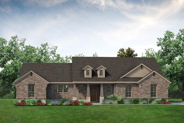 new england style home with a front lawn, brick siding, and roof with shingles