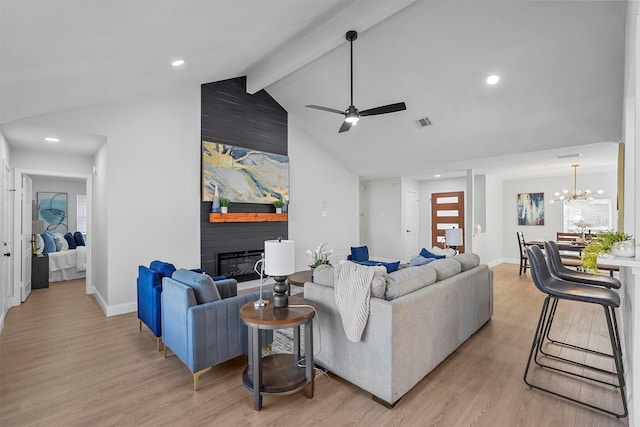 living room with light hardwood / wood-style flooring, a large fireplace, a wealth of natural light, beamed ceiling, and ceiling fan with notable chandelier