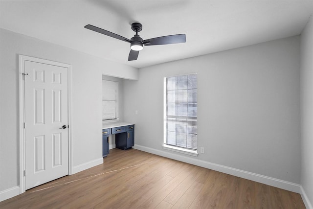 unfurnished bedroom featuring ceiling fan, light wood-type flooring, and multiple windows